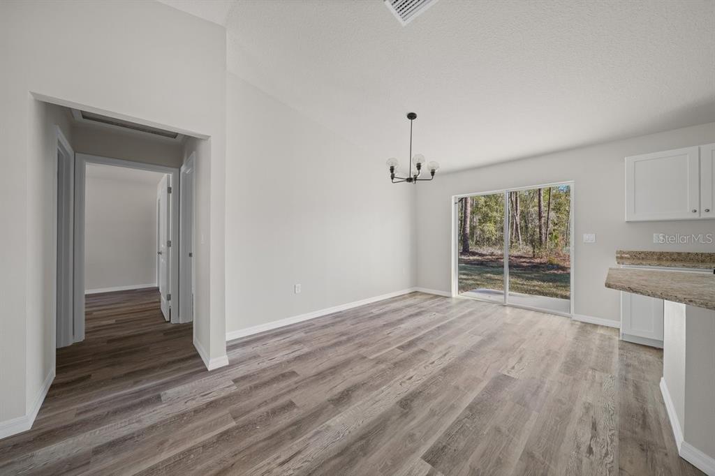 8992 North Lisa Terrace Citrus Springs, FL 34433 - Photo 11 of 25 a view of empty room with wooden floor and window