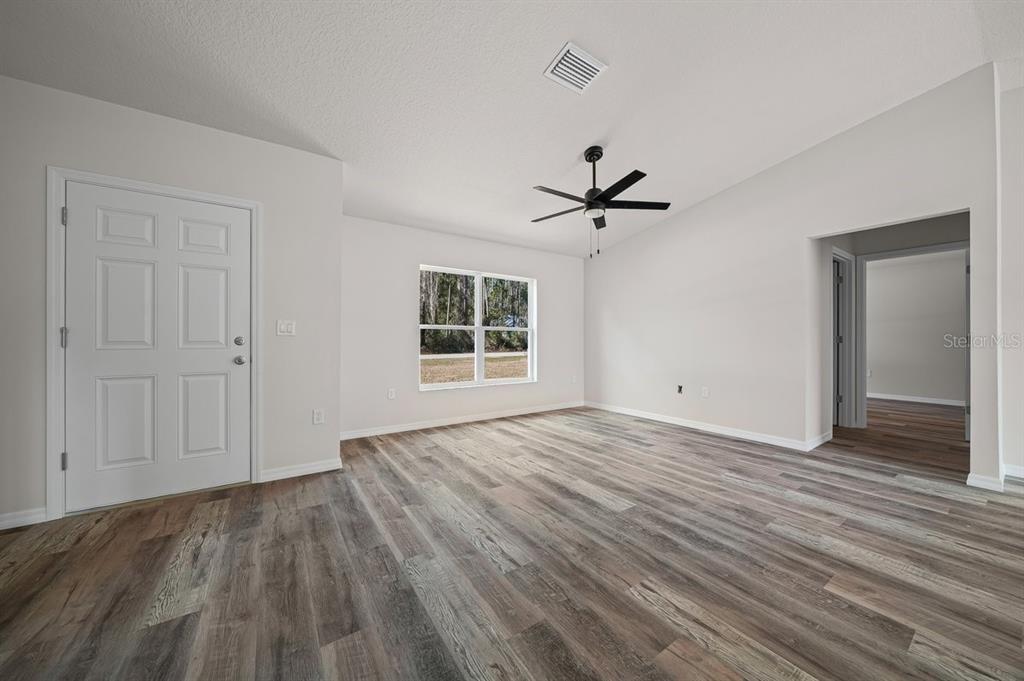 8992 North Lisa Terrace Citrus Springs, FL 34433 - Photo 12 of 25 a view of empty room with wooden floor and fan