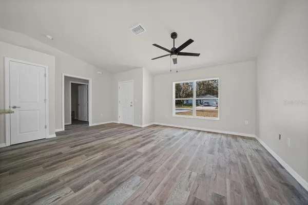 a view of empty room with wooden floor and window