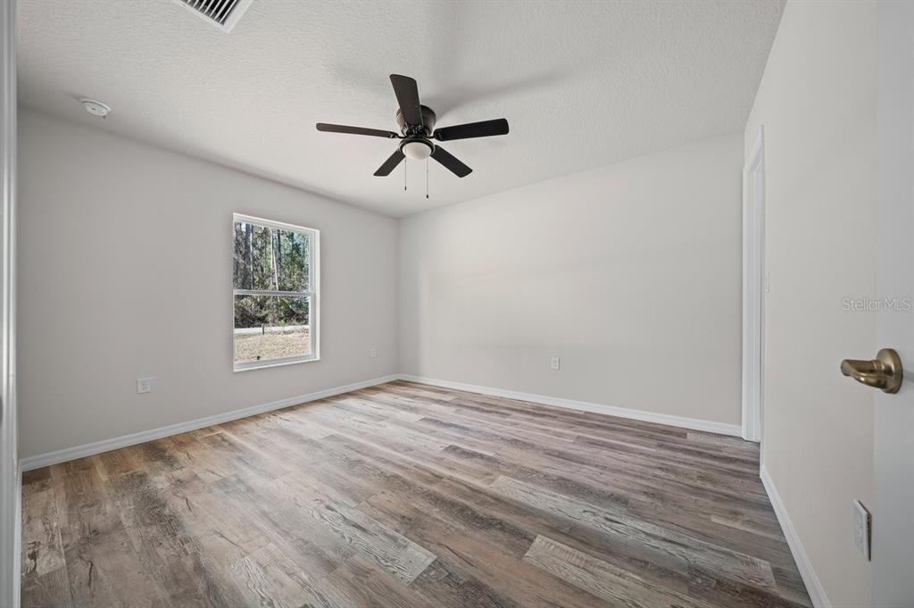 8992 North Lisa Terrace Citrus Springs, FL 34433 - Photo 19 of 25 a view of empty room with wooden floor and window