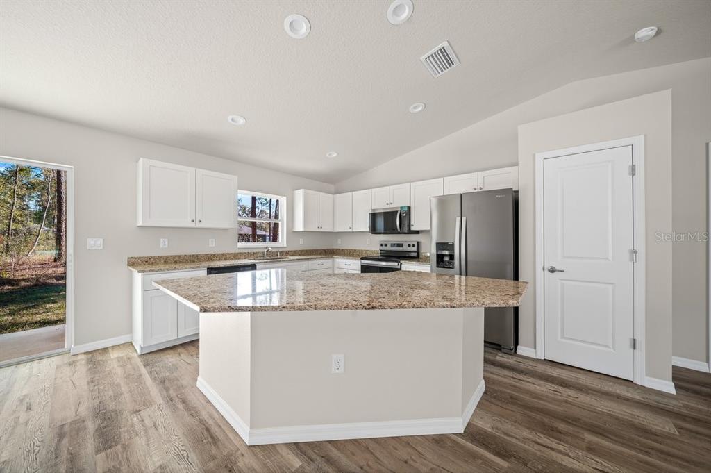 8992 North Lisa Terrace Citrus Springs, FL 34433 - Photo 6 of 25 a large kitchen with stainless steel appliances granite countertop a lot of counter space and wooden floor