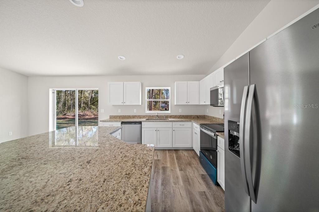 8992 North Lisa Terrace Citrus Springs, FL 34433 - Photo 7 of 25 a kitchen with stainless steel appliances granite countertop a refrigerator sink and stove