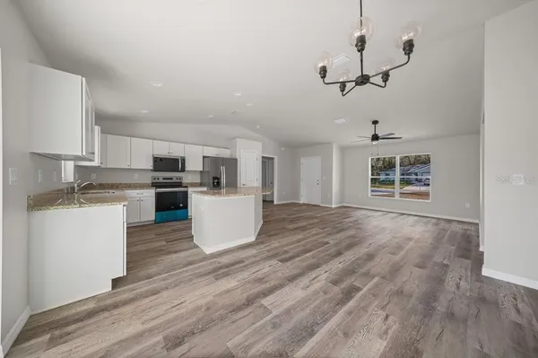a view of kitchen with sink and refrigerator