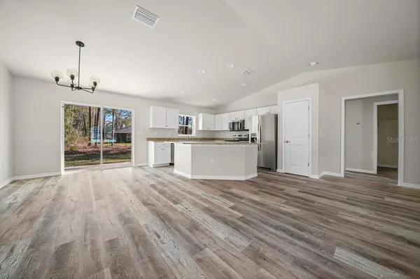 a view of a kitchen with wooden floor and a window