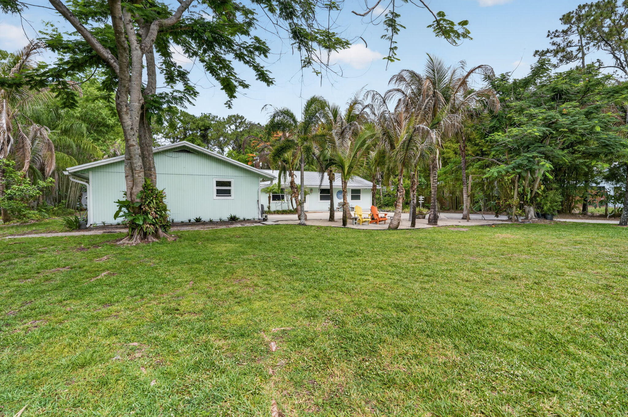 17391 Alexander Run Jupiter, FL 33478 - Photo 46 of 55 a view of a white house with a big yard and palm trees