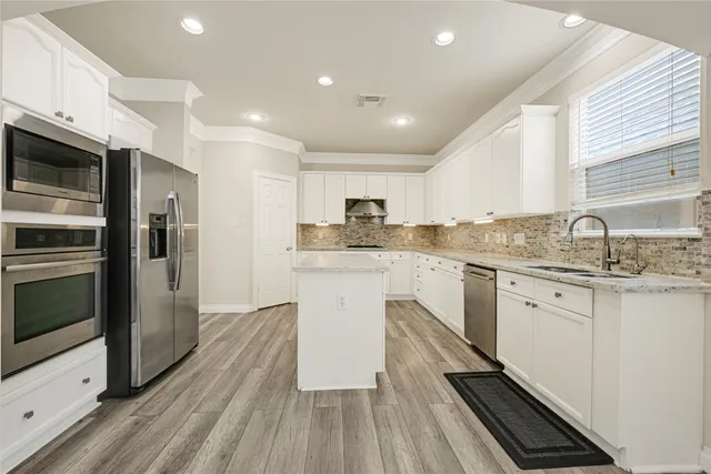 a kitchen with granite countertop stainless steel appliances cabinets a sink and a counter top space