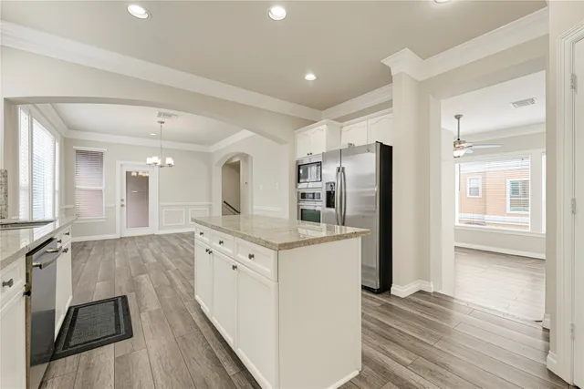 a kitchen with stainless steel appliances granite countertop a refrigerator and a stove top oven