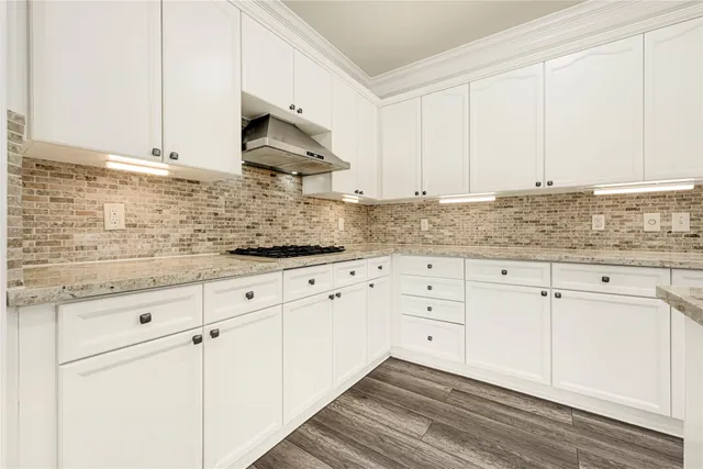 a kitchen with granite countertop white cabinets and white appliances