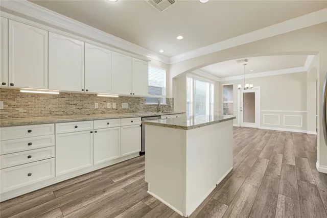 a kitchen with granite countertop white cabinets and white appliances
