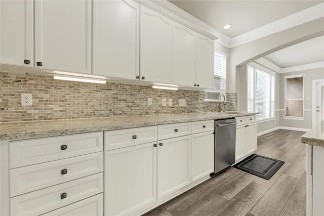 a kitchen with granite countertop white cabinets and white appliances