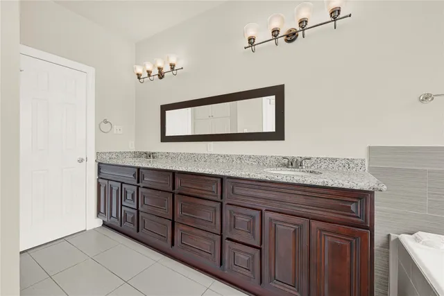 a bathroom with a granite countertop sink and a mirror