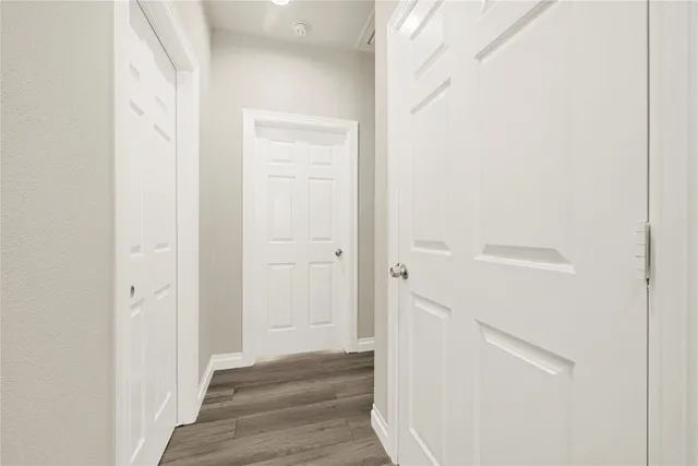 a view of a hallway with wooden floor