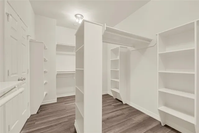 a view of a hallway with wooden floor and closet