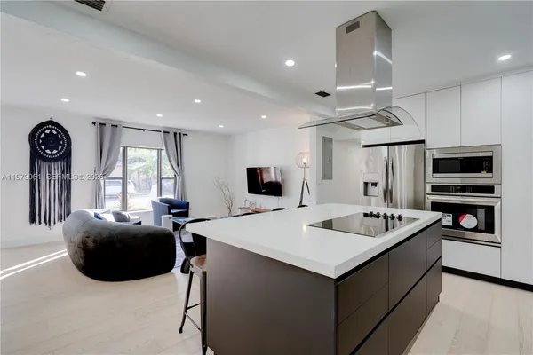 a large white kitchen with a large island