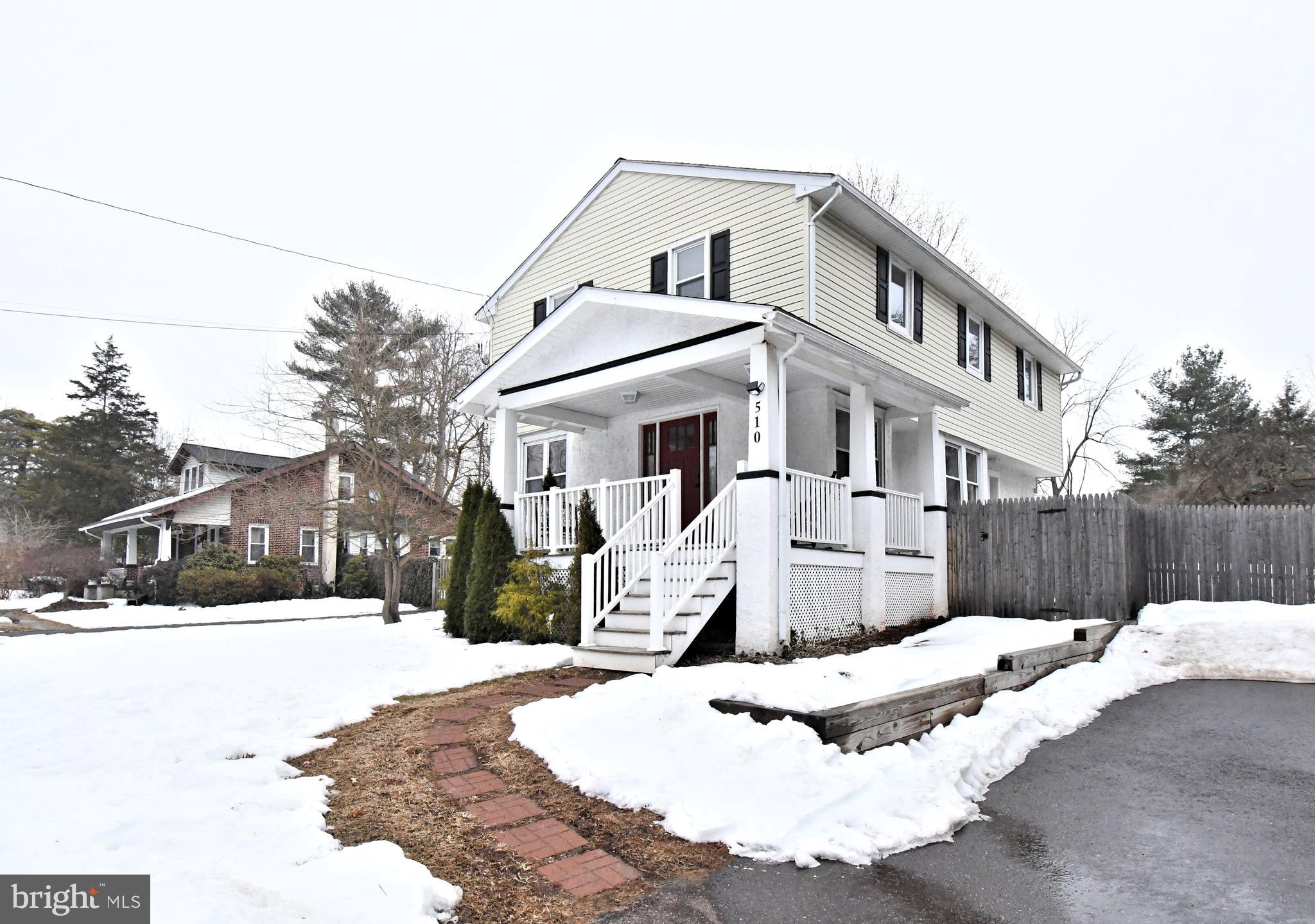 a view of a white house with a yard covered in snow