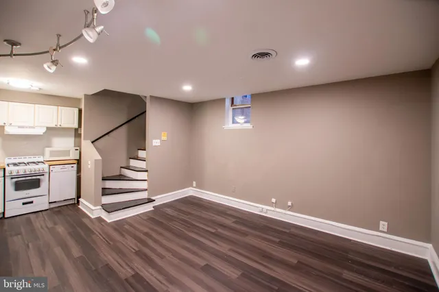 a view of an empty room with wooden floor