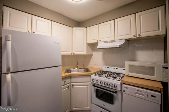 a kitchen with stainless steel appliances granite countertop a refrigerator sink and stove