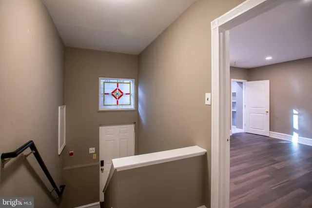 a view of a hallway with wooden floor