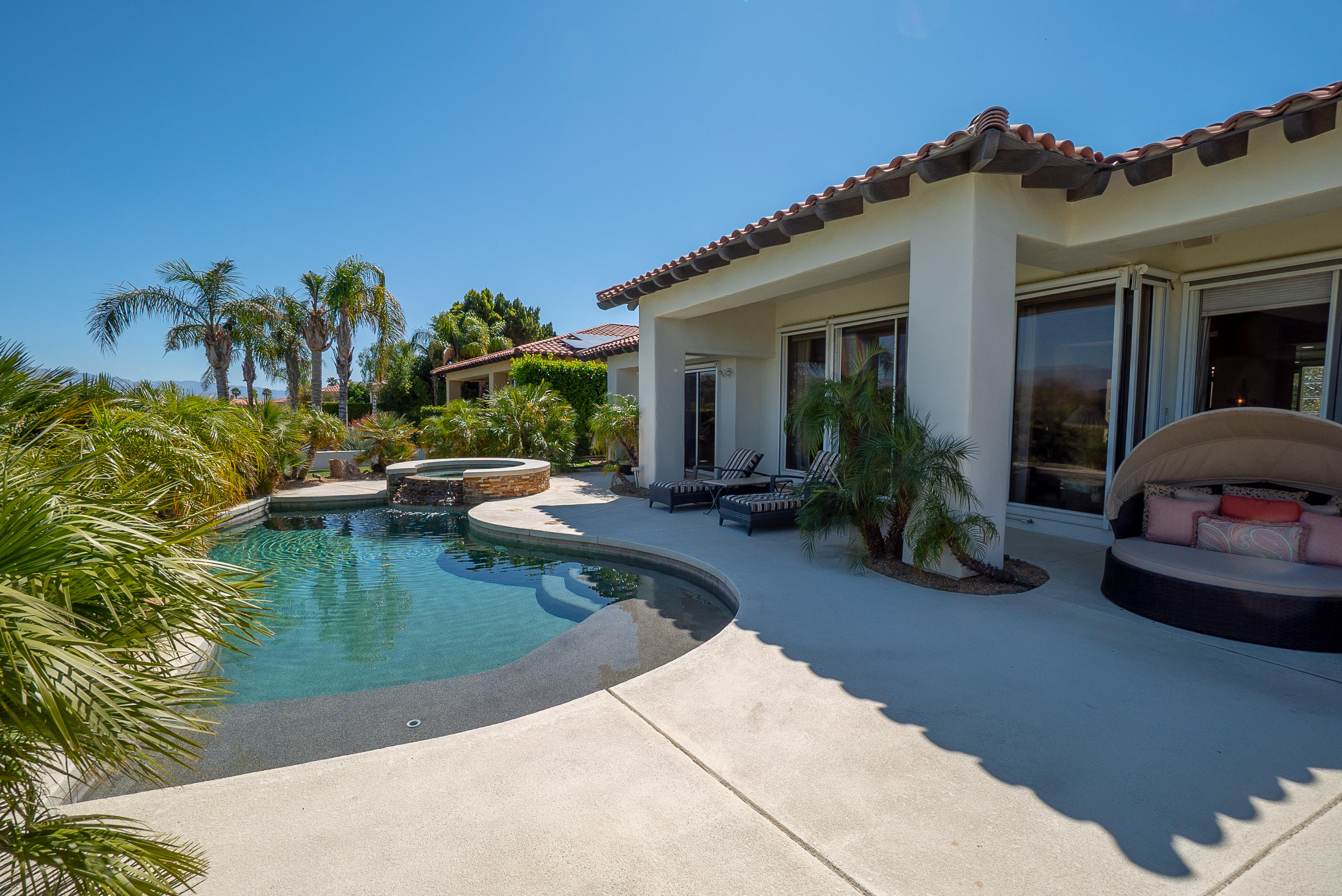 a view of a house with swimming pool next to a yard