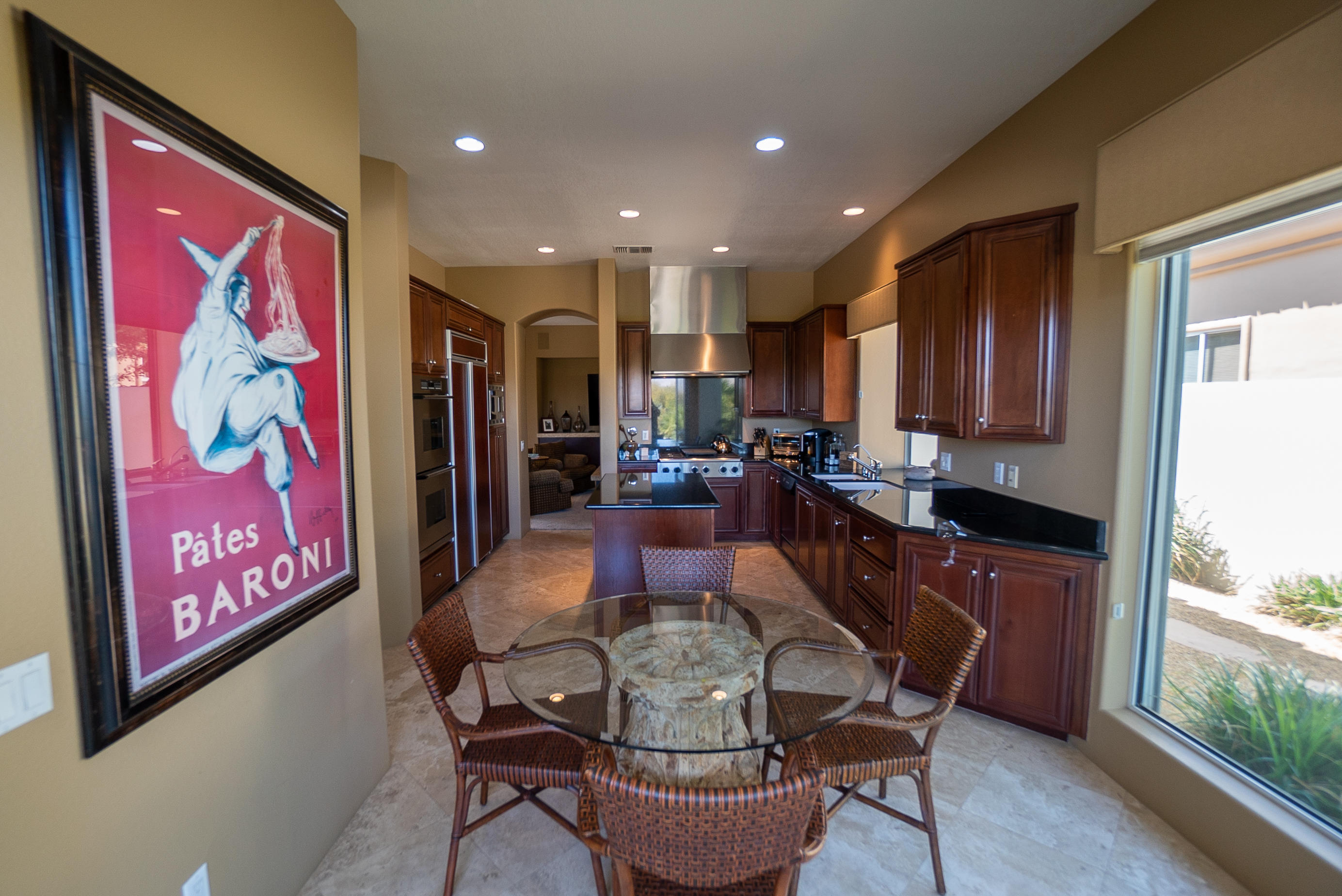144 Loch Lomond Road Rancho Mirage, CA 92270 - Photo 13 of 28 a kitchen with stainless steel appliances granite countertop a refrigerator a stove top oven a sink and dishwasher with wooden floor