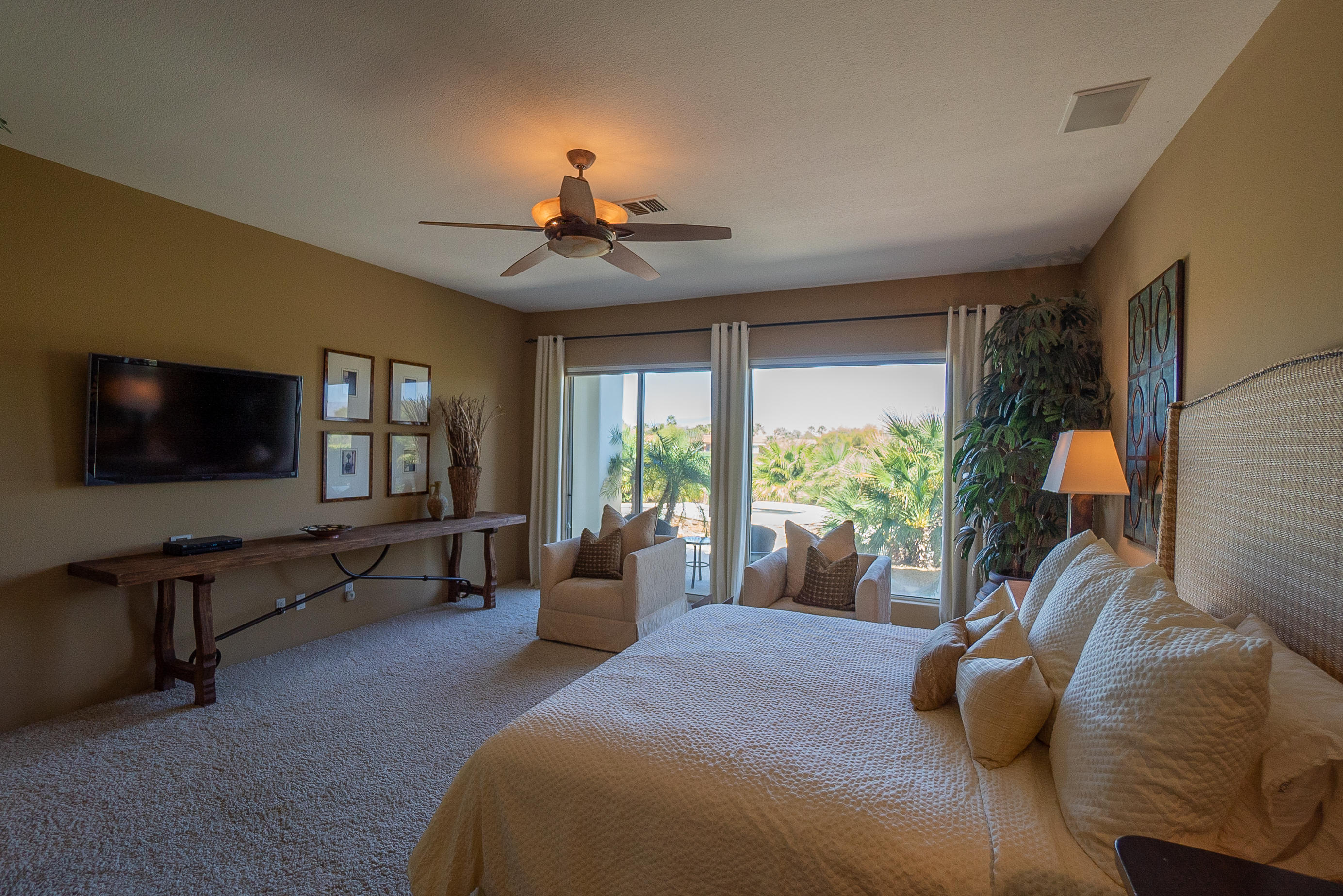 144 Loch Lomond Road Rancho Mirage, CA 92270 - Photo 18 of 28 a bedroom with a large bed and a flat tv screen on dresser