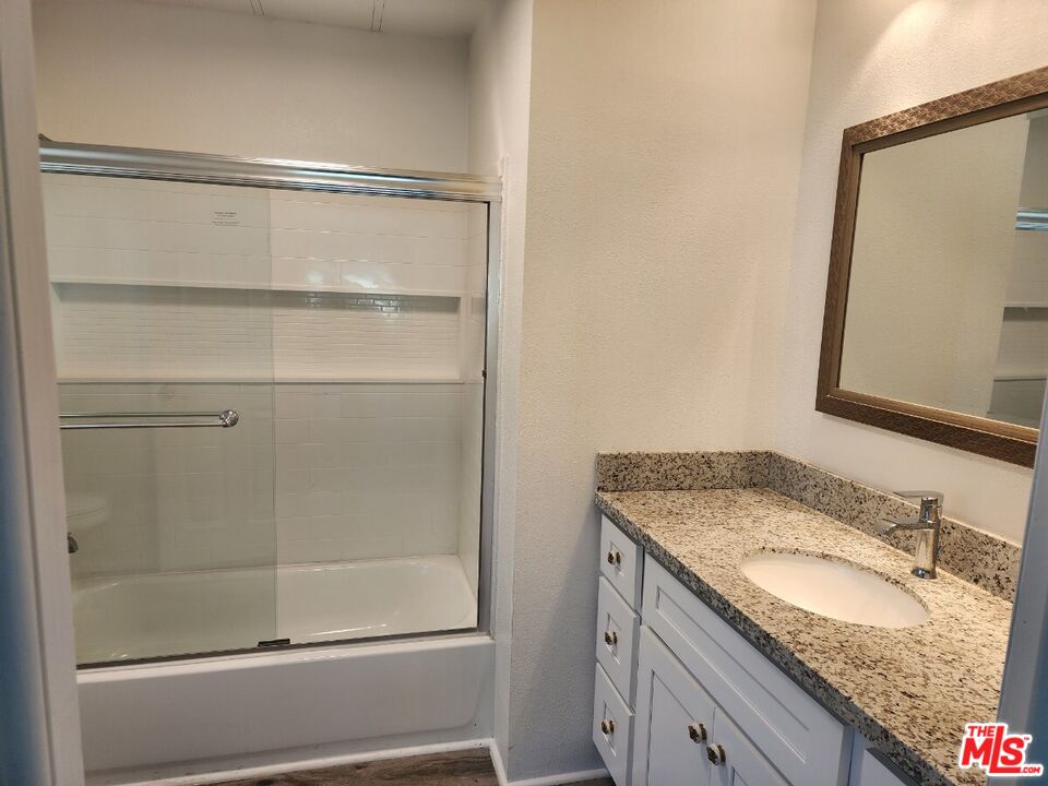 17700 South Avalon Boulevard, Unit 221 Carson, CA 90746 - Photo 6 of 14 a bathroom with a granite countertop sink and mirror with bathtub