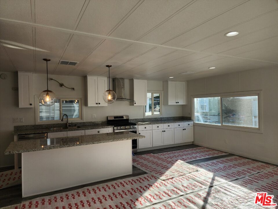 17700 South Avalon Boulevard, Unit 221 Carson, CA 90746 - Photo 10 of 14 a large kitchen with stainless steel appliances kitchen island granite countertop a sink and cabinets