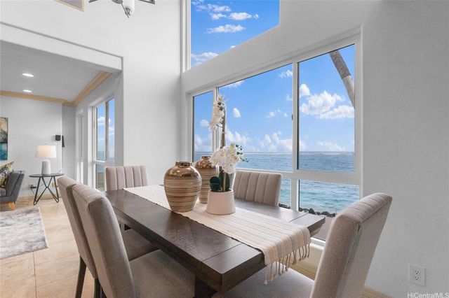 a dining room with furniture a large window and a chandelier