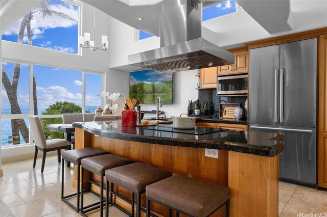 a kitchen with stainless steel appliances granite countertop table chairs sink and window