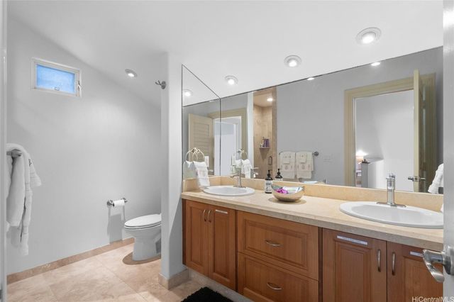 a bathroom with a double vanity sink toilet and a mirror