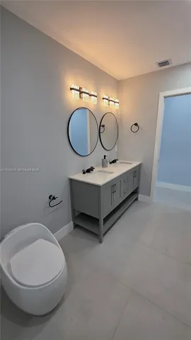 a bathroom with a toilet a sink and a mirror