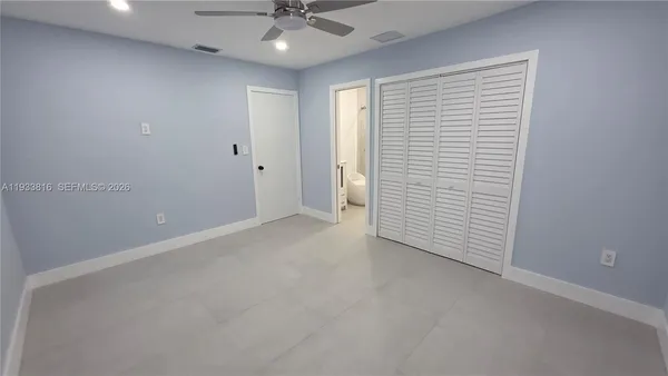 an empty room with a ceiling fan and a window