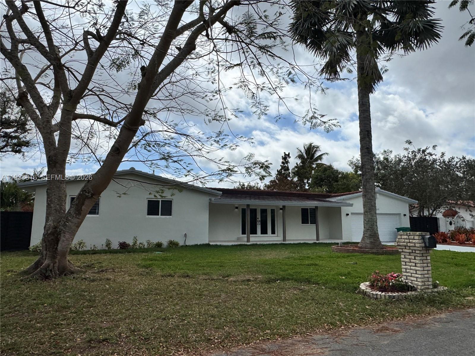 10540 Southwest 125th Street Miami, FL 33176 - Photo 2 of 31 a view of a white house with a yard and large tree
