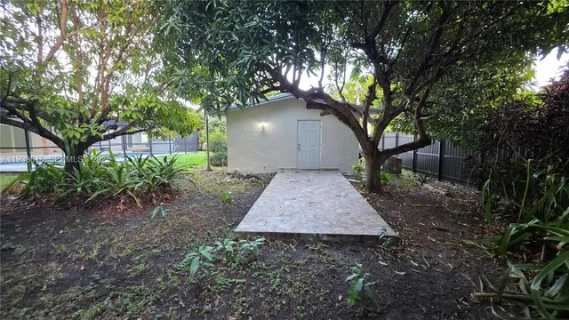 a view of a backyard with large trees