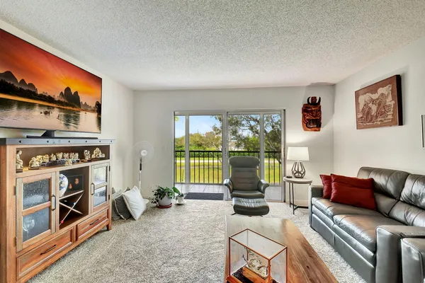 a living room with furniture a floor to ceiling window and a flat screen tv