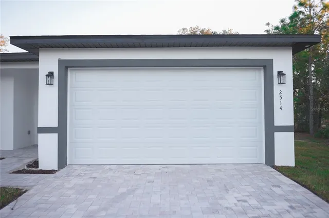 a view of a hallway with wooden floor and a bathroom