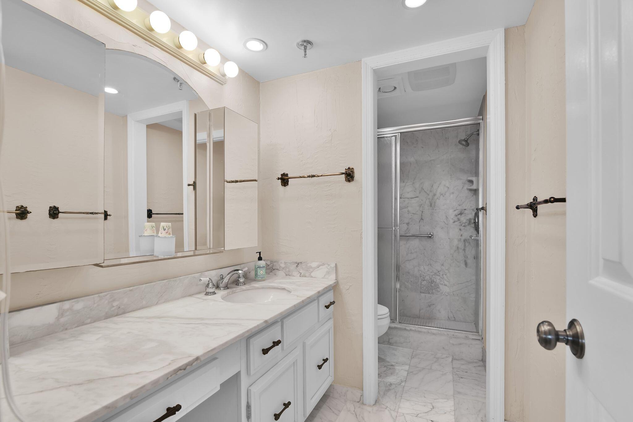 899 Jeffery Street, Unit 809 Boca Raton, FL 33487 - Photo 33 of 96 a bathroom with a granite countertop sink a mirror and a shower