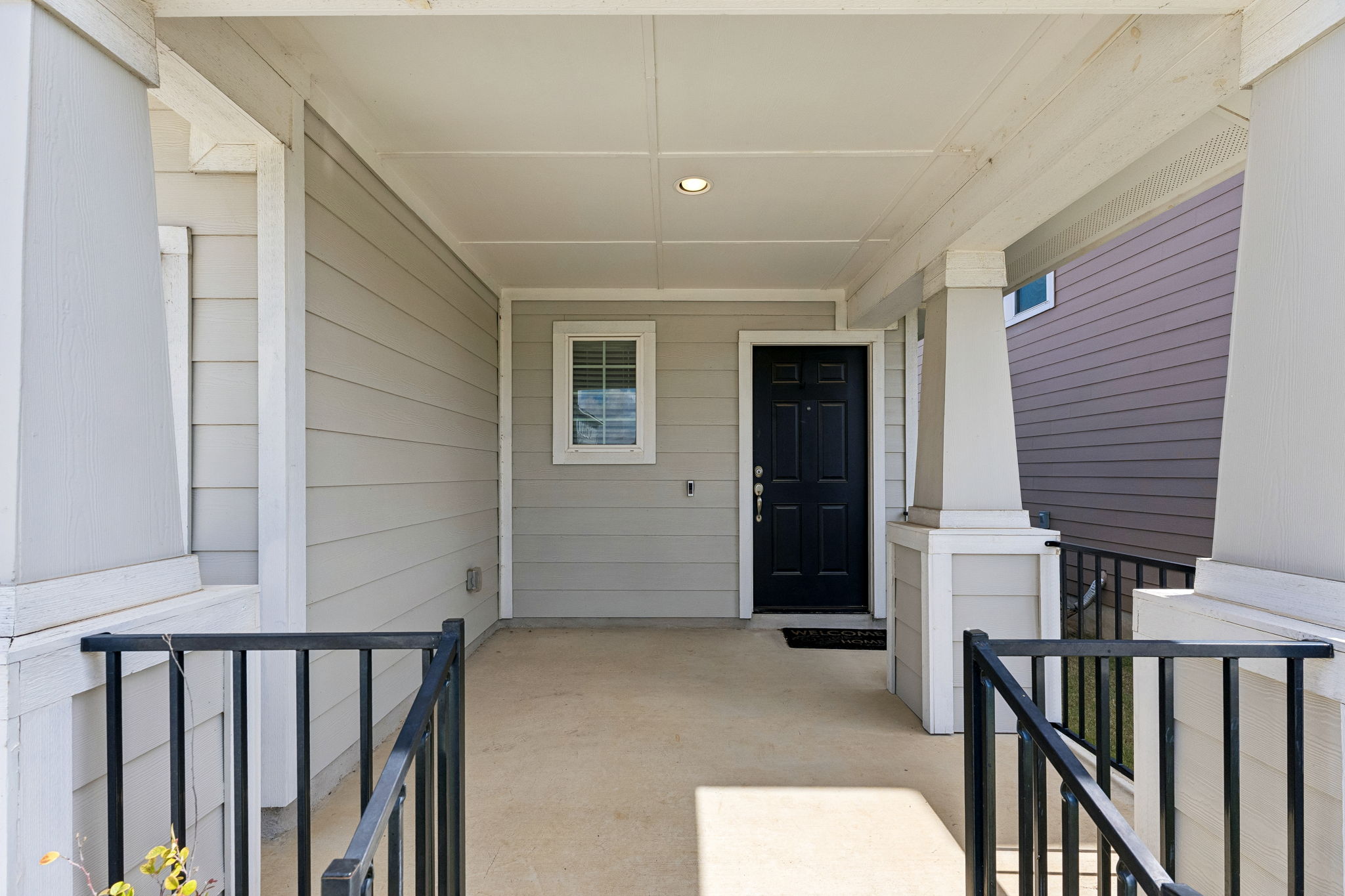 164 Appleberry Lane Elgin, TX 78621 - Photo 3 of 40 A welcoming front porch features classic columns, clean siding, and a recessed ceiling light.