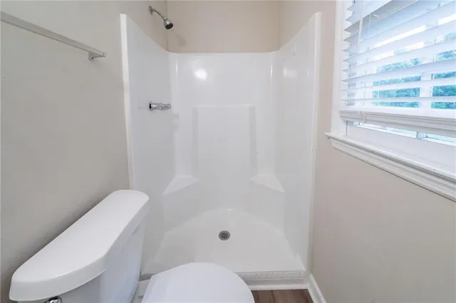 a bathroom with a toilet and a shower