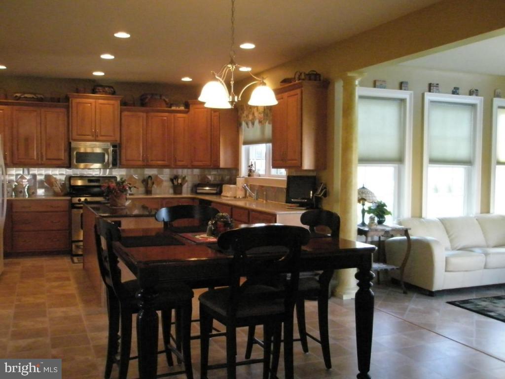 3008 Weaver Road Lititz, PA 17543 - Photo 5 of 12 a kitchen with granite countertop a table chairs stove a sink and dishwasher