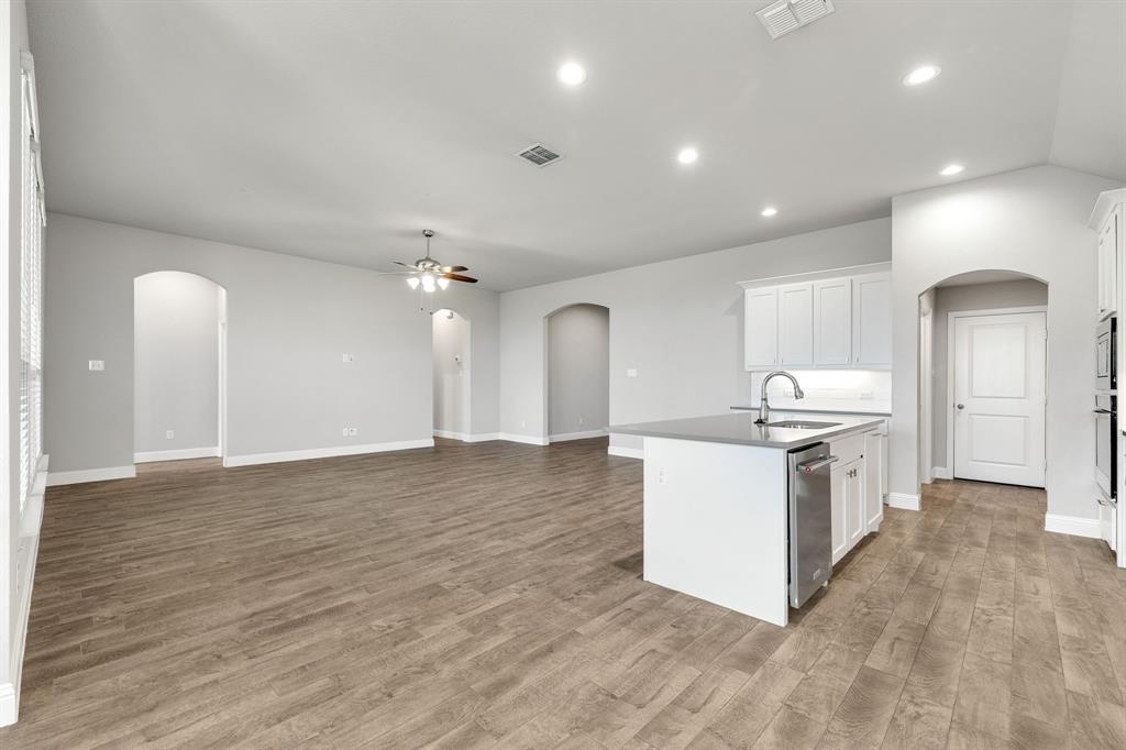 915 Timber Ridge Drive Justin, TX 76247 - Photo 12 of 39 Expansive living area featuring wood-finish flooring, recessed lighting, and arched doorways