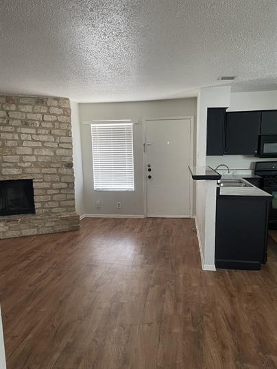 9806 Roxanna Drive, Unit C Austin, TX 78748 - Photo 2 of 6 an empty room with kitchen view and a fireplace