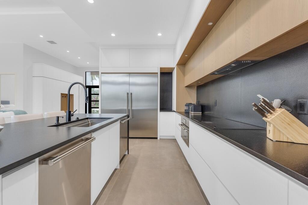 923 Eve Street Delray Beach, FL 33483 - Photo 17 of 69 a large kitchen with stainless steel appliances granite countertop a sink and a refrigerator