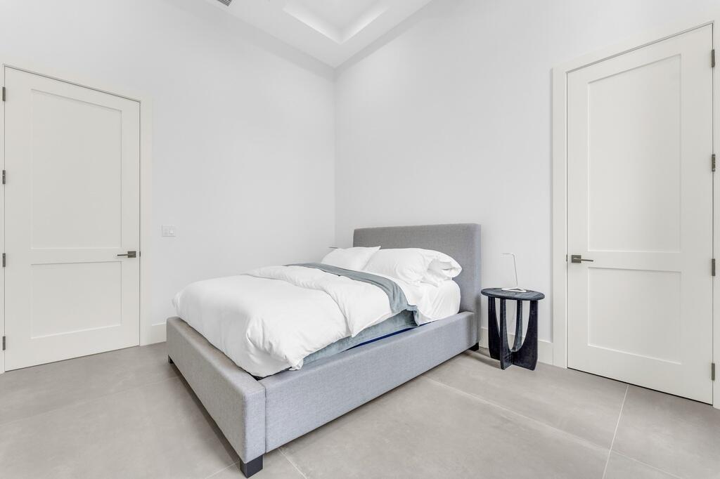 923 Eve Street Delray Beach, FL 33483 - Photo 30 of 69 a bed sitting in a bedroom next to a bathroom