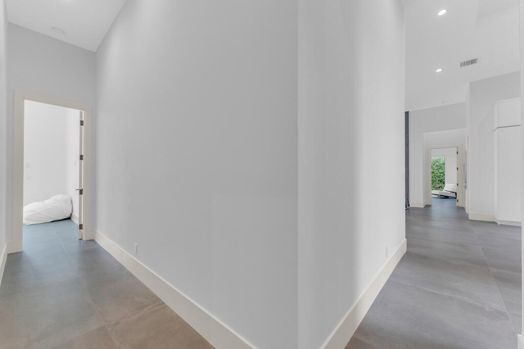 923 Eve Street Delray Beach, FL 33483 - Photo 37 of 69 a view of a hallway with wooden floor and a bathroom