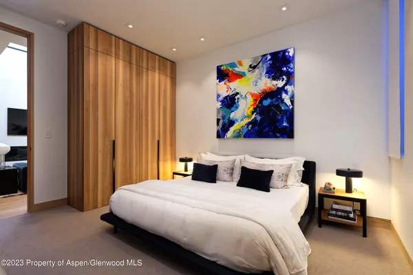 a bedroom with a bed and glass wall