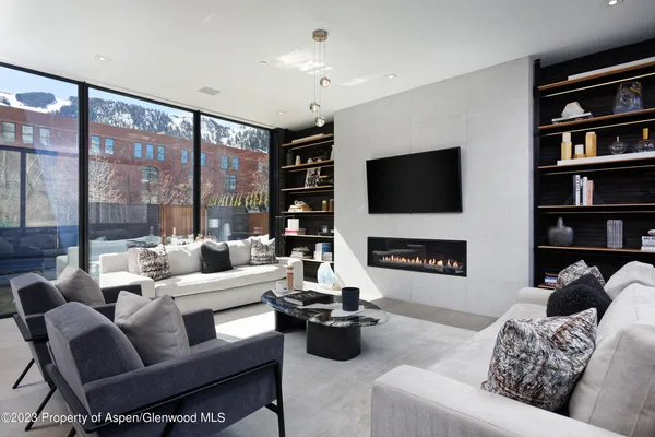 a living room with furniture a large window and a flat screen tv