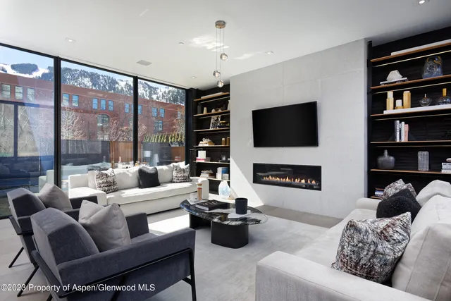 a living room with furniture a large window and a flat screen tv