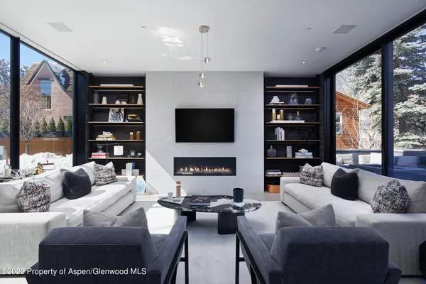 a living room with furniture a bookshelf and a flat screen tv