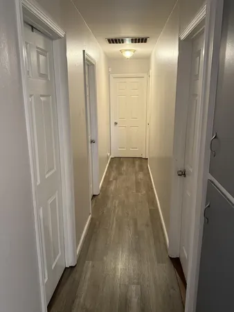a view of a hallway with wooden floor